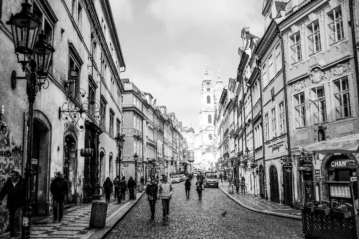 A cobbled old-town street with a church tower in the distance — Classic B&W 400